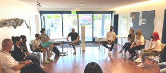 Gruppe von Jugendlichen diskutieren im Kreis