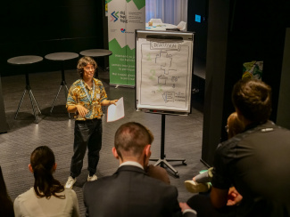 Teammitglied von engage.ch steht vor Plakat mit Informationen zum Ablauf des Bundeshausevents.