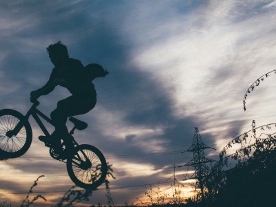 Ausriss eines BMX-Fahrrades mit einerPerson darauf, in der Luft