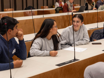 Jugendliche diskutieren im Rathaus Zürich ihre Anliegen an die Stadt und lachen zusammen vor den Mikrofonen.